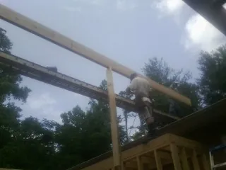 Carpenter setting a ridge beam over a new addition frame — Ice Dam Removal by Roofing Brothers in Berkeley Heights
