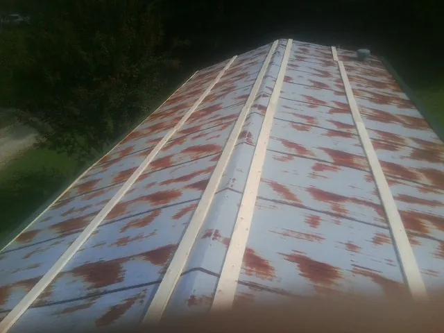 Rusted metal roof panels with new wood purlins before replacement — Storm Damage Roof Repair in Berkeley Heights by Roofing Brothers