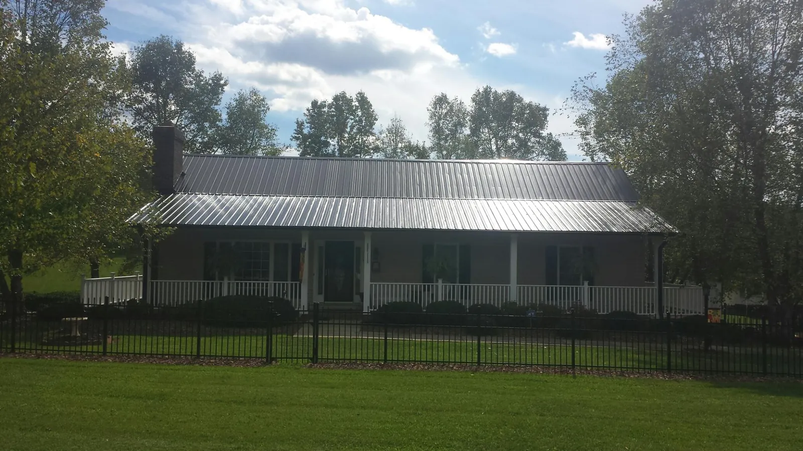 Gray metal roof on a brick ranch with a full width front porch — Gutter Guard Installation work by our crew in Berkeley Heights