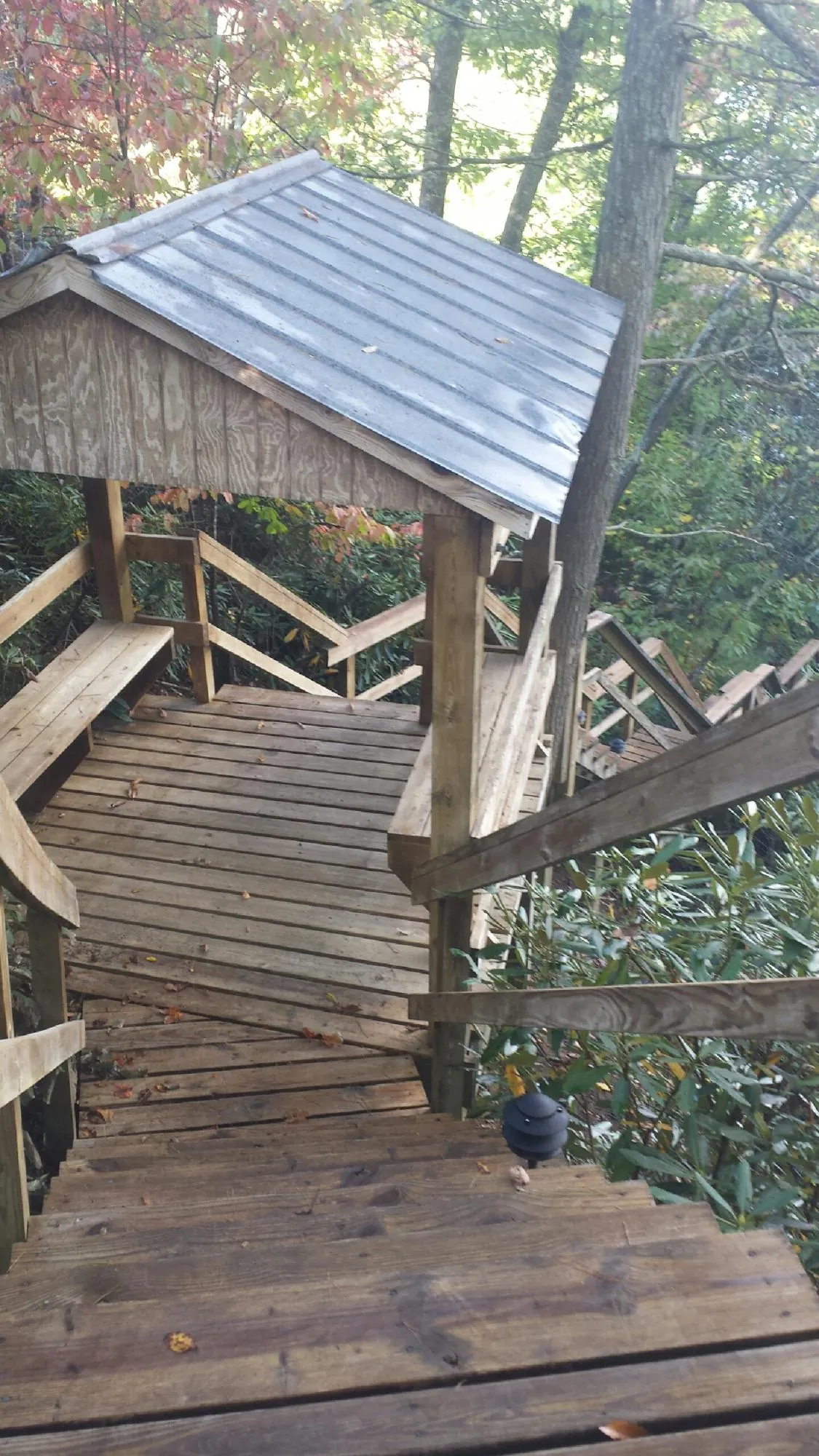 Metal roofed shelter over wooden steps on a wooded walkway — Skylight Repair & Installation work by our crew in Berkeley Heights