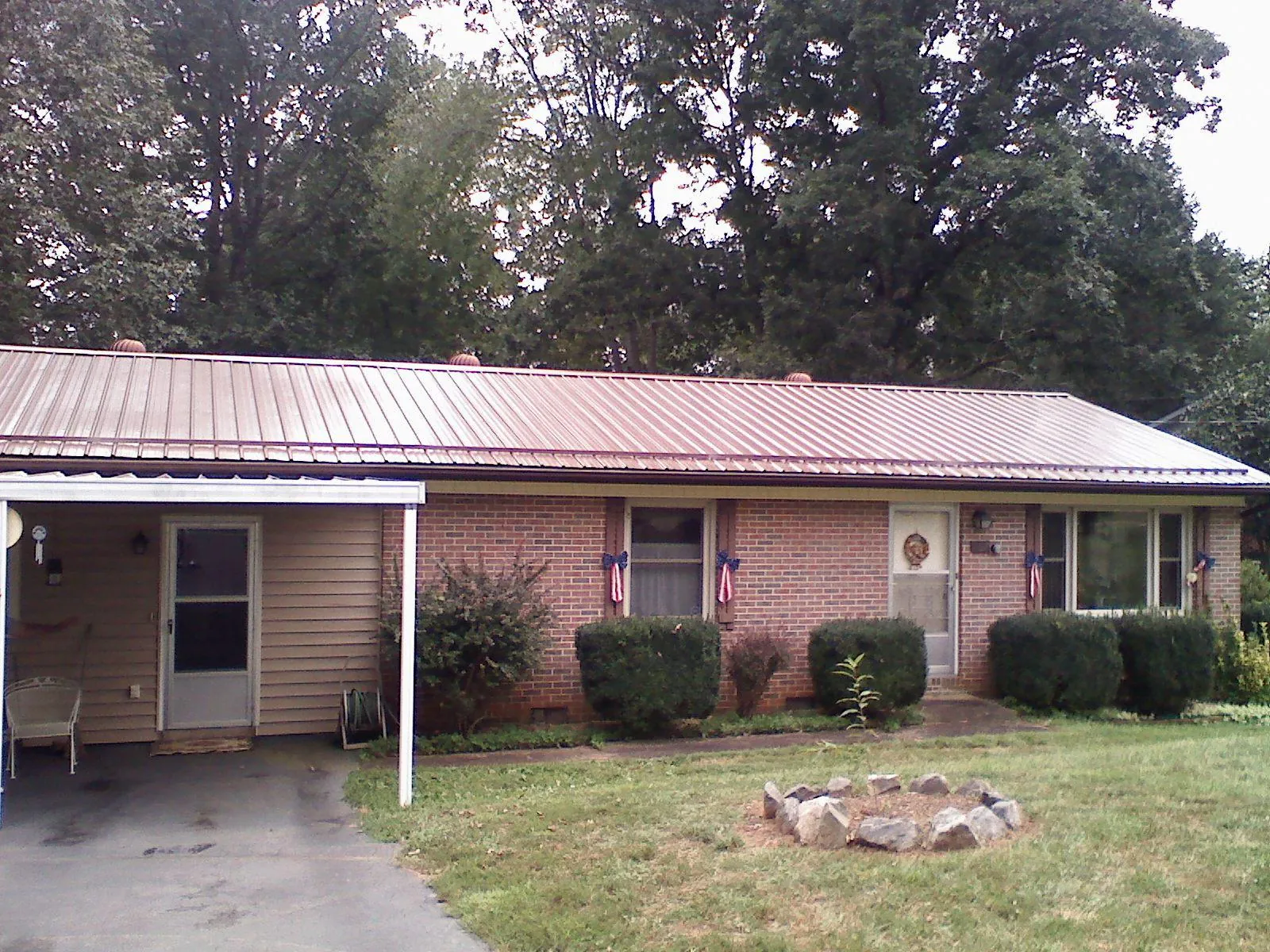 Bronze metal roof and carport on a brick ranch home — Roof Repair work by our crew in Berkeley Heights